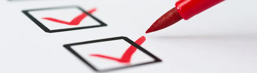 une checklist en entrain d’être cochée au stylo rouge