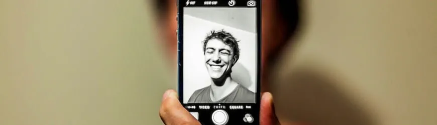 Un jeune homme se prend en photo pour illustrer son profil de réseau social professionnel LinkedIn.
