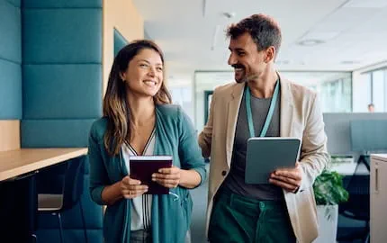 Une femme salariée et un homme salarié qui sourient, rémunérés de façon égale dans leur entreprise.
