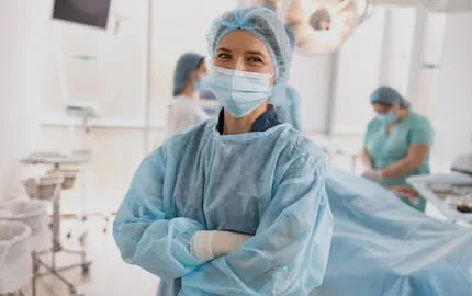 chirurgienne dans un bloc opératoire habillée avec masque, charlotte, gants