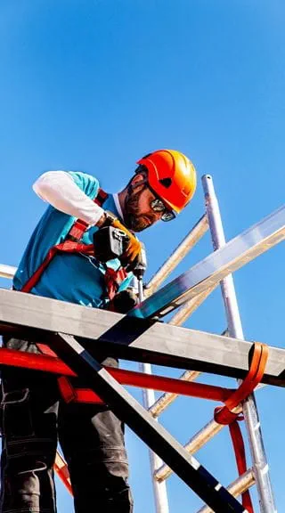 Trabajador asegurando una viga de acero en altura con equipo de seguridad