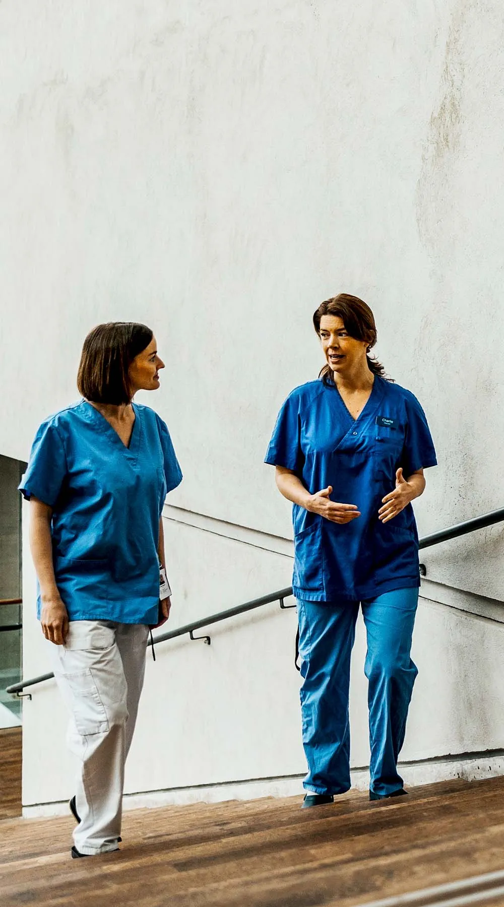 Dos trabajadores de la salud caminando fuera de un edificio Dos trabajadores de la salud caminando fuera de un edificio