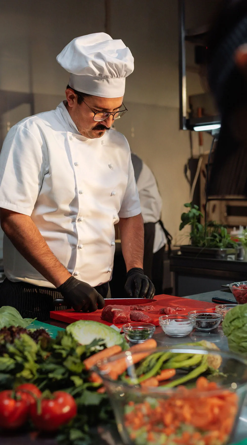 Chef cortando carne con precisión en la ajetreada cocina de un restaurante