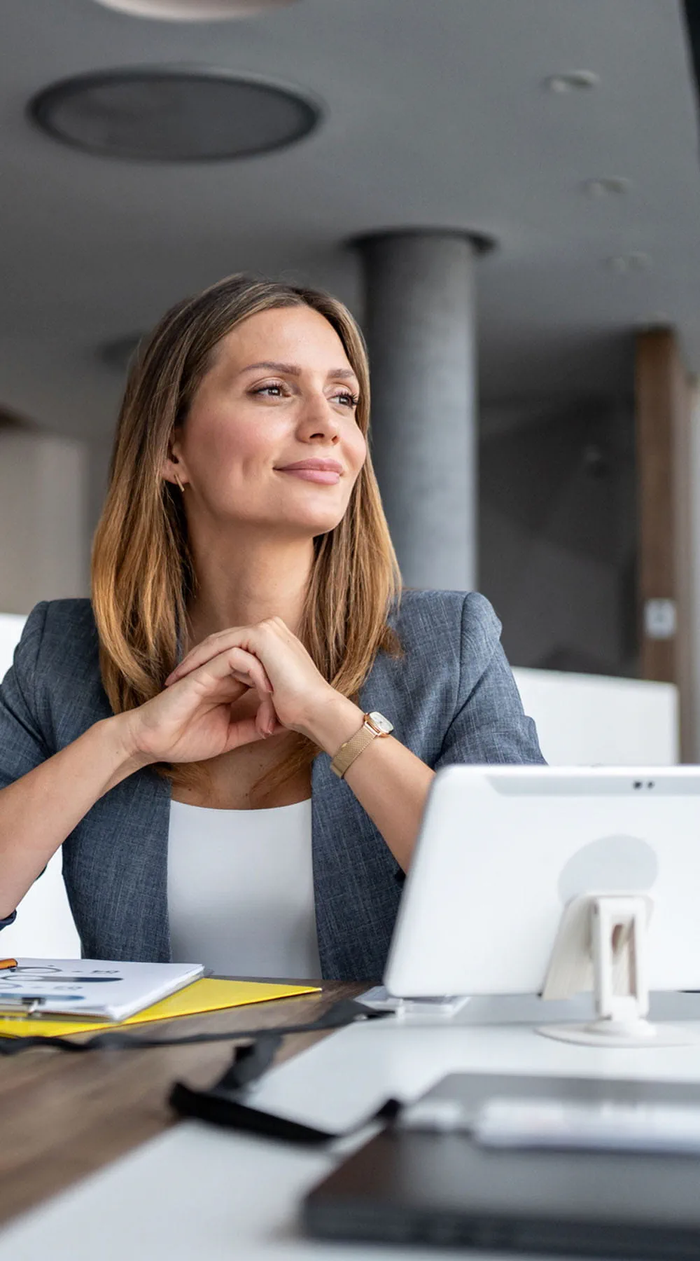 Mujer mirando hacia otro lado mientras está sentada en el escritorio
