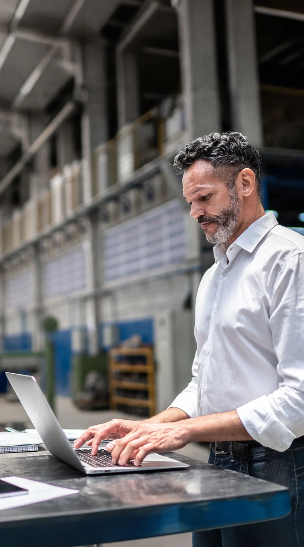 Hombre de negocios que usa computadora portátil en una fábrica