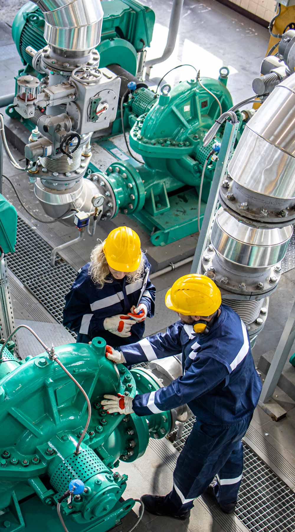 Trabajadores industriales de gas revisando las bombas de tuberías y motores en la fábrica