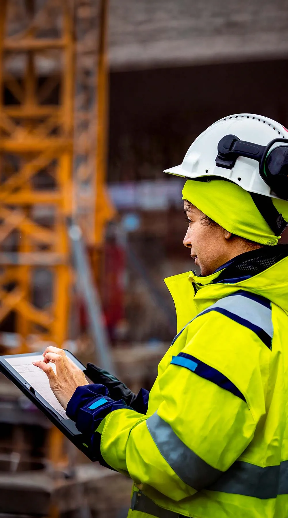Ingeniero revisando planos en una tableta en el sitio de construcción