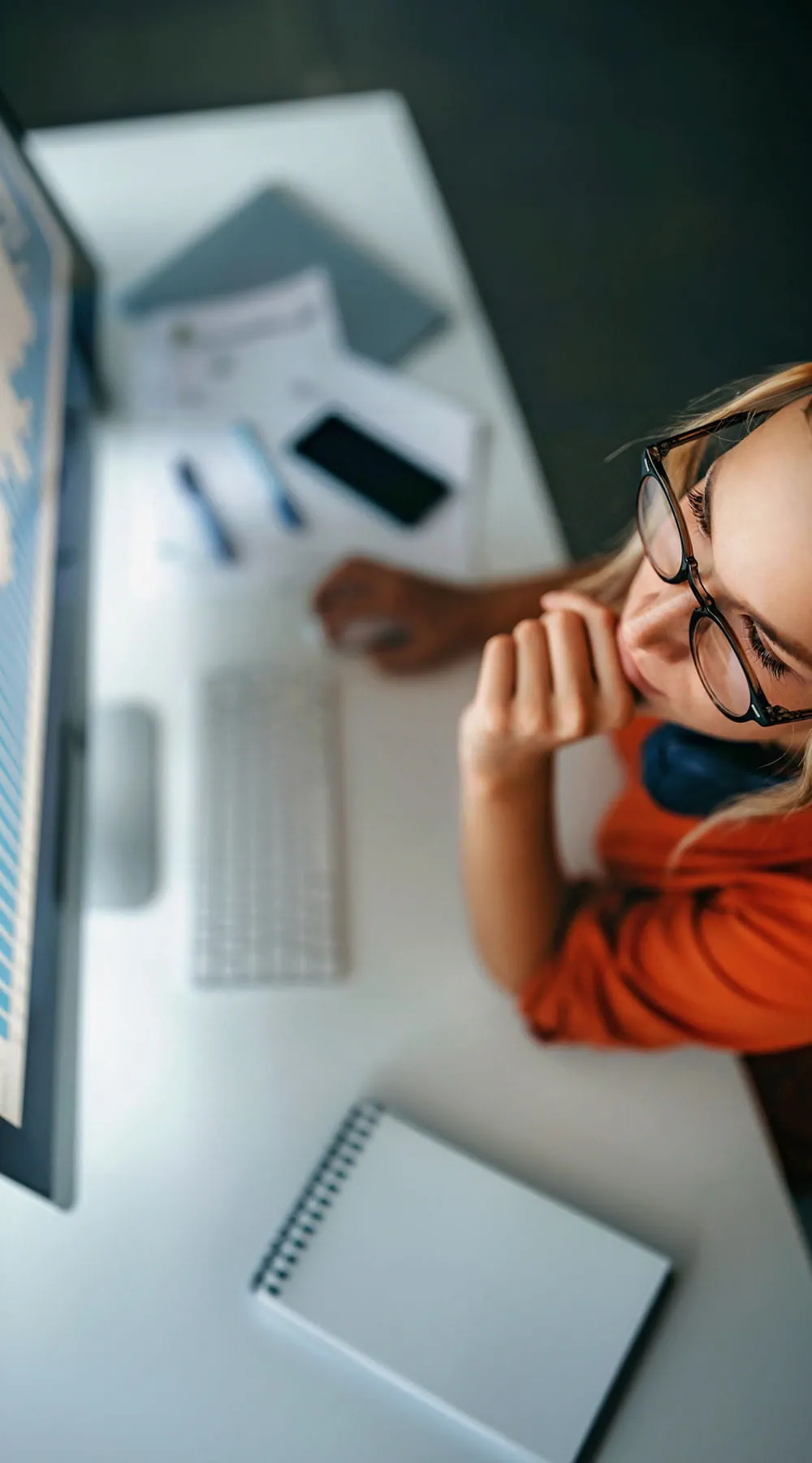 Mujer joven revisando gráficos en la pantalla del ordenador