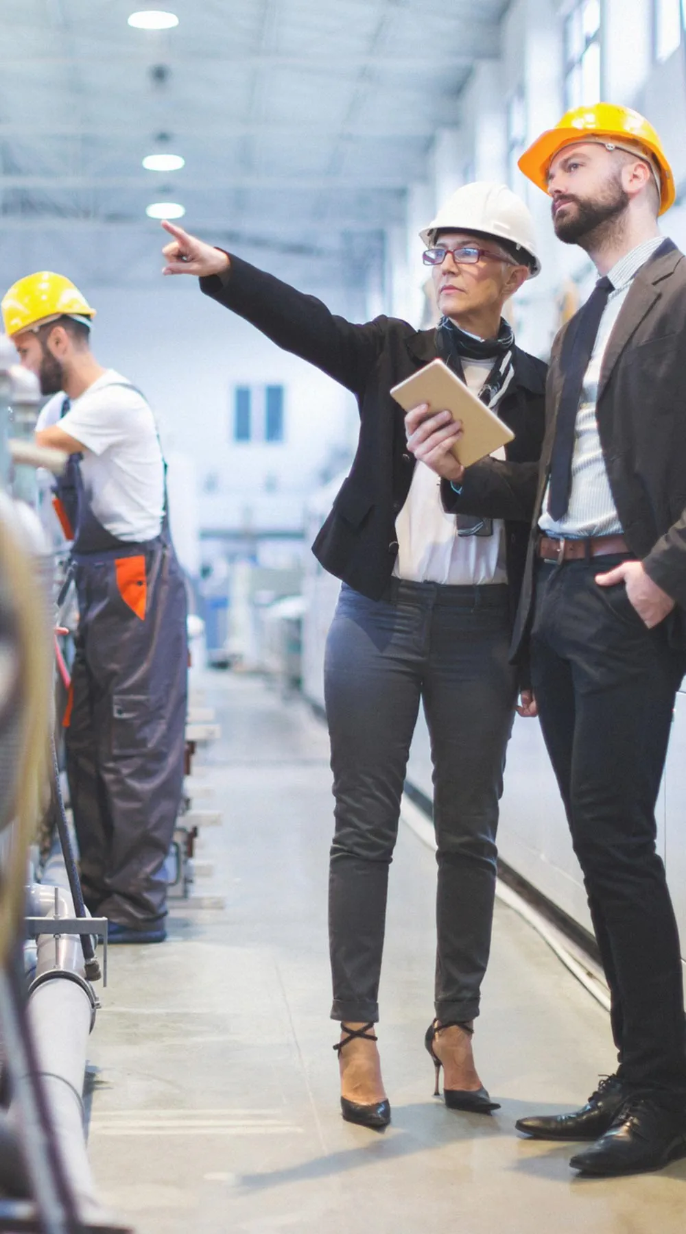 Dos personas con casco revisando línea de producción