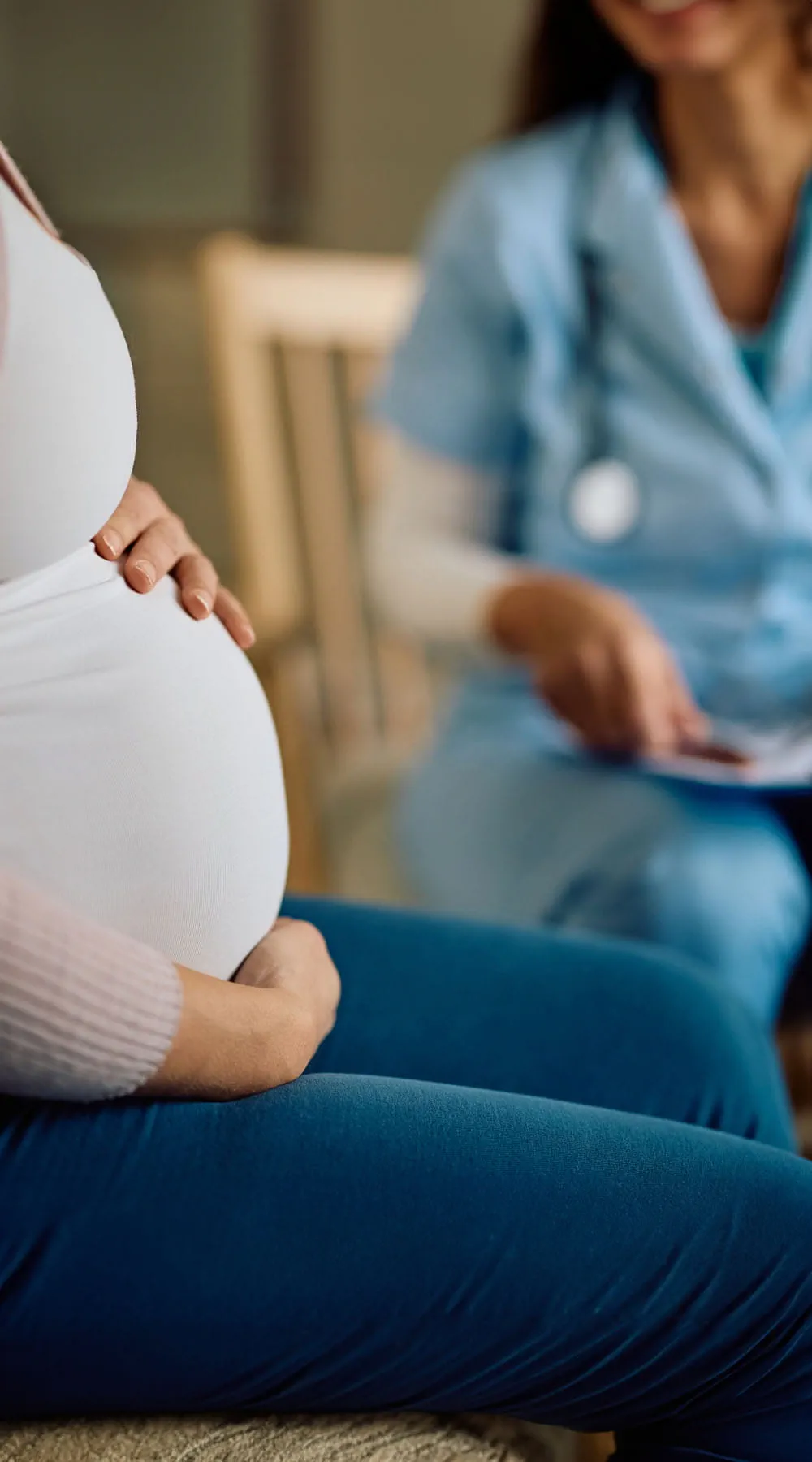 Primer plano de una mujer embarazada durante una visita domiciliaria de una enfermera obstetra