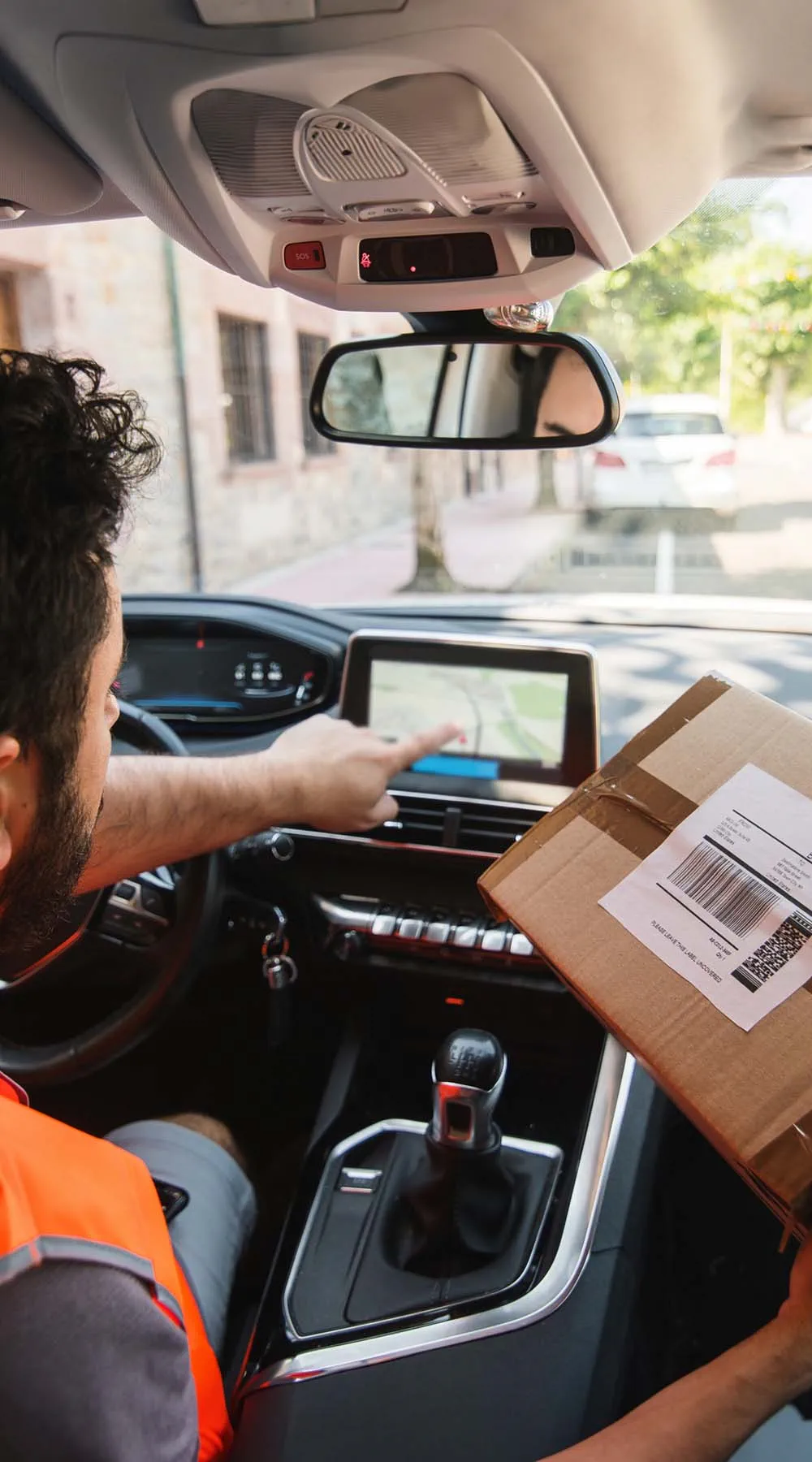 Trabajador postal con paquetería en coche