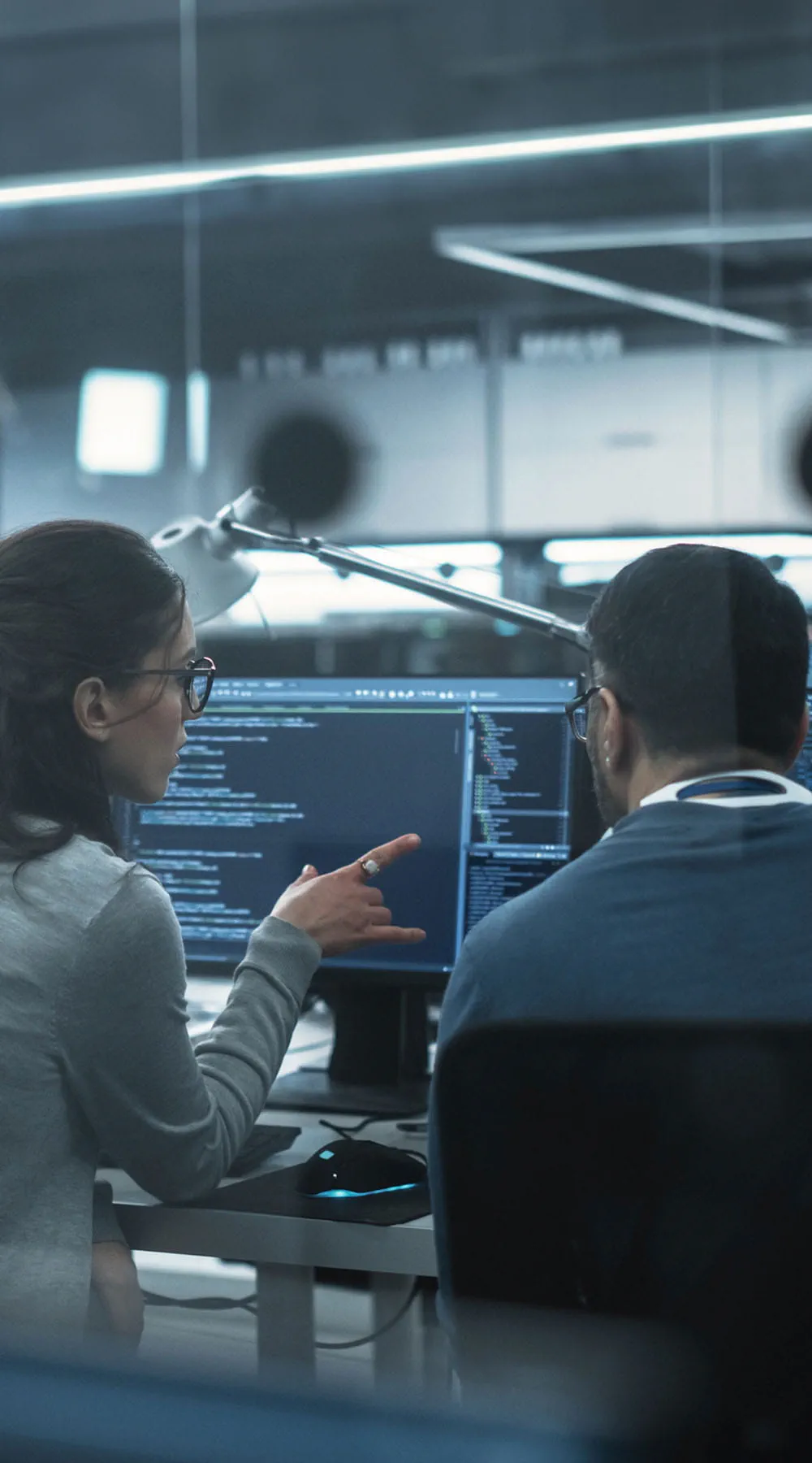 Dos desarrolladores de software diversos teniendo una reunión en una sala de conferencias