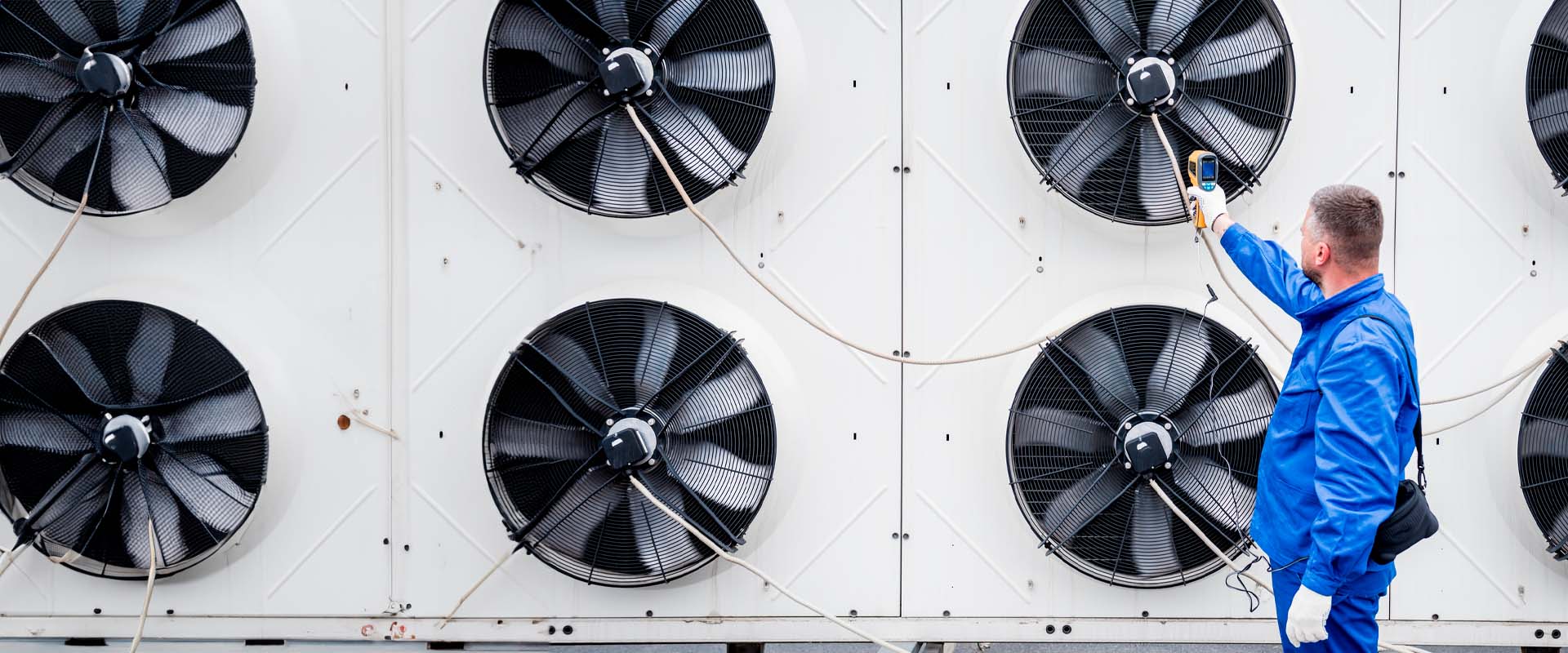 Técnico utilizando un termómetro infrarrojo para comprobar el intercambiador de calor de la unidad de condensación Técnico utilizando un termómetro infrarrojo para comprobar el intercambiador de calor de la unidad de condensación