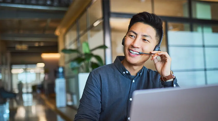 Agente de servicio al cliente asiático hablando por auriculares
