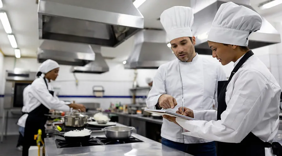 Chef hablando con un estudiante en una clase de cocina