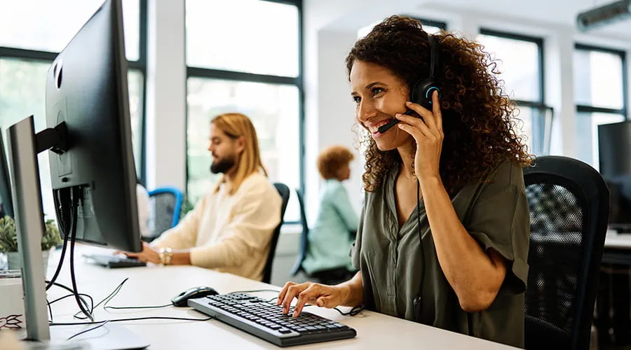 Mujer trabajando con ordenador en un call center de coworking