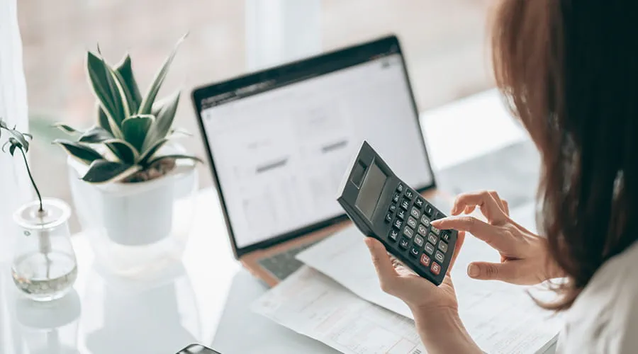 Analista financiera revisando resultados con calculadora