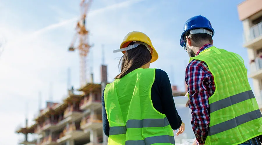Trabajador de la construcción y su gerente comprobando el progreso