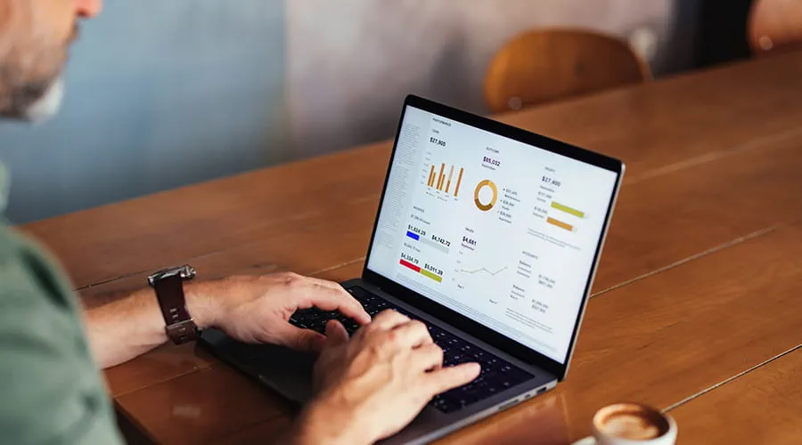 Hombre de negocios trabajando en unos datos con gráficos en un ordenador portátil