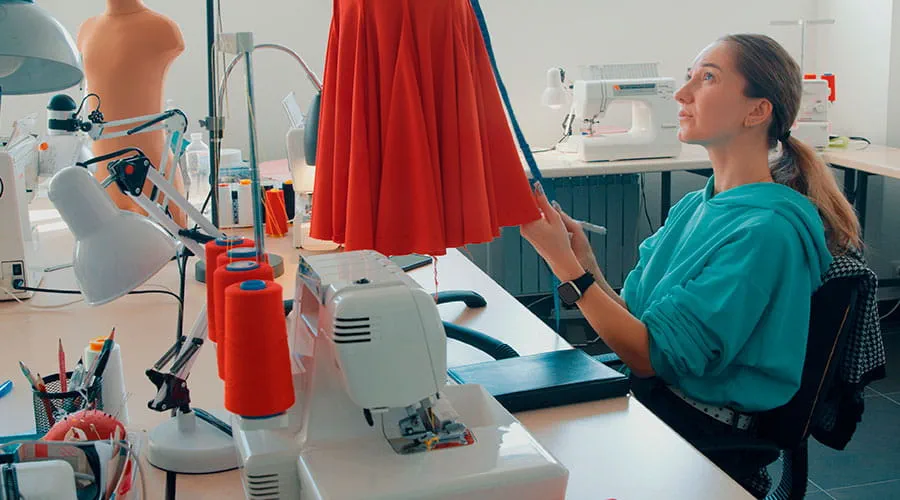 Diseñadora de moda creando vestido en taller de costura