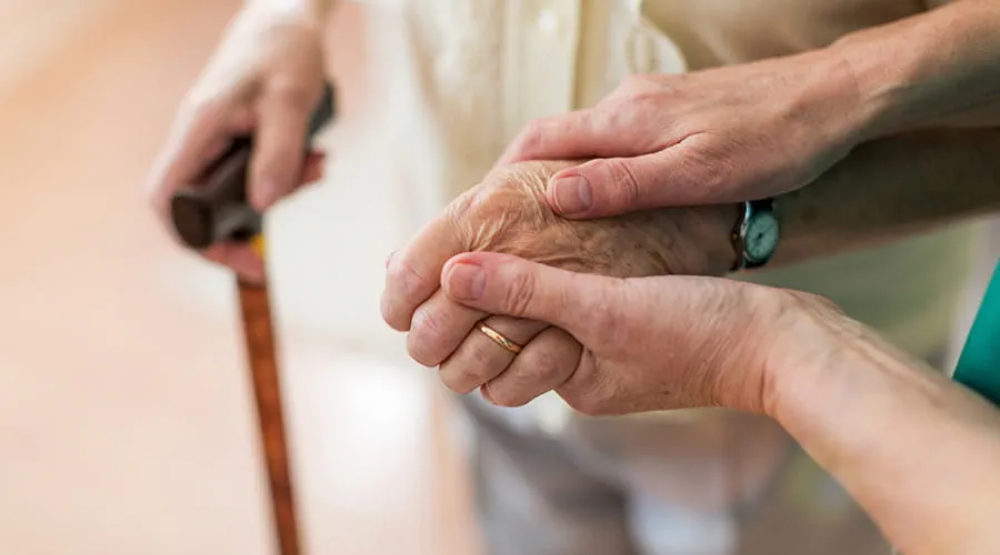 Manos sujetando manos de una persona anciana