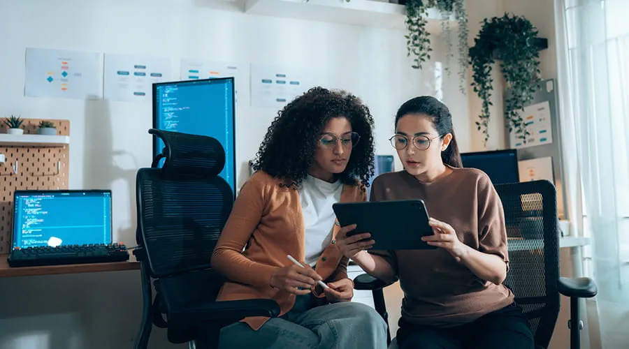 Dos chicas jóvenes revisando datos en una tablet