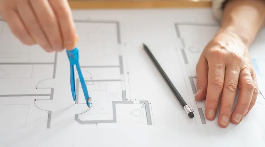 Manos moviendo un compás sobre un plano