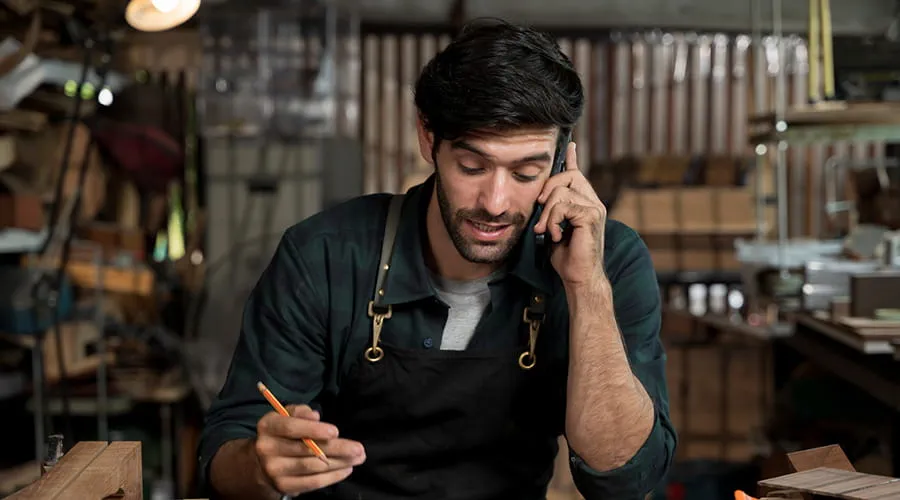 Hombre en taller hablando por teléfono