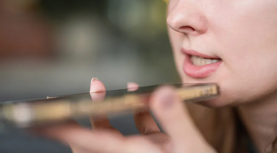 Mujer joven grabando una nota de audio con su teléfono inteligente