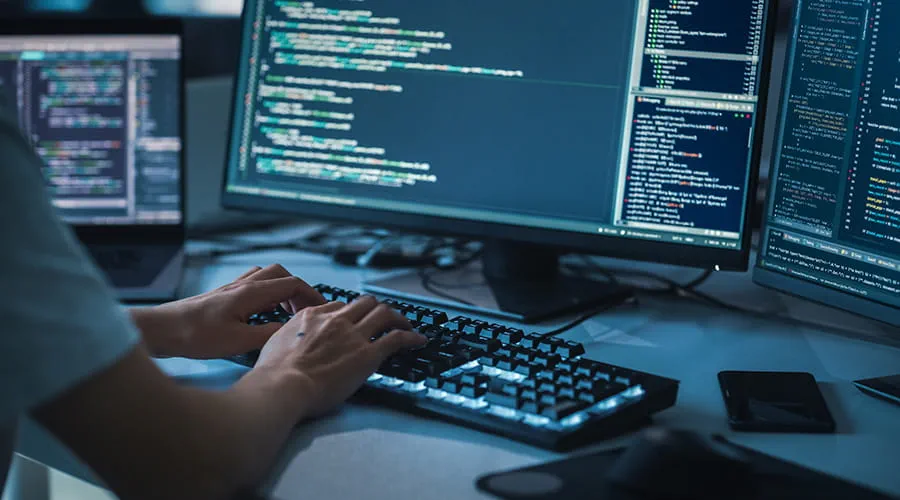 Primer plano enfoque manos de una persona escribiendo en el teclado retroiluminado