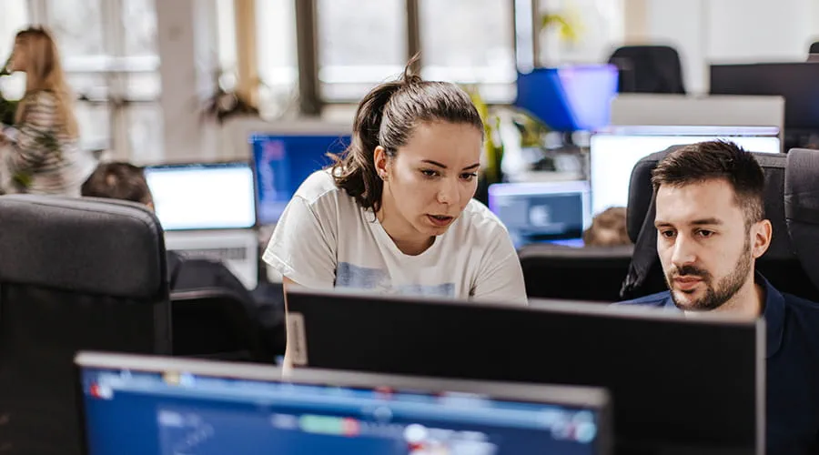 Dos personas jóvenes revisando información en un ordenador