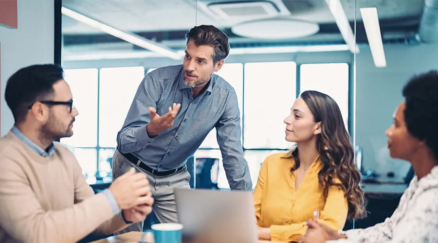 Jefe de equipo hablando en una reunión con más personas