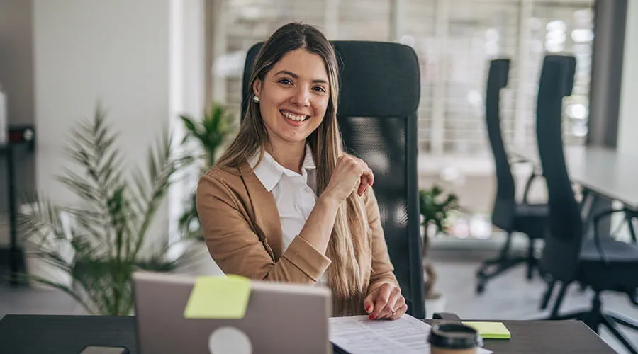 Mujer de negocios en su despacho mirando a cámara