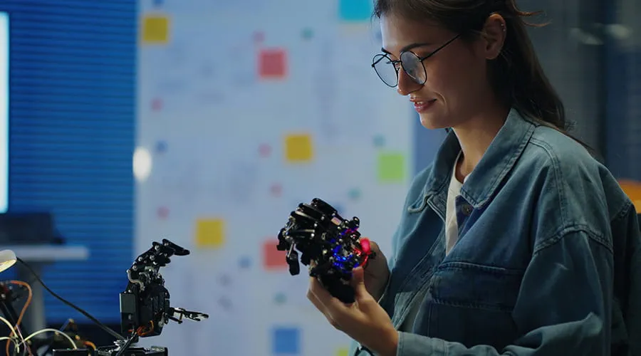 Ingeniera que trabaja con la mano de un robot