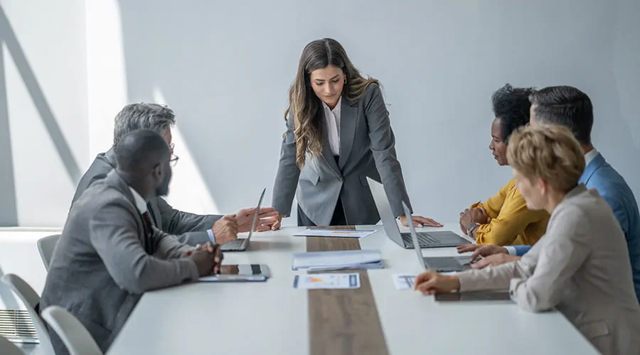 Mujer liderando una reunión con su equipo en la sala de conferencias