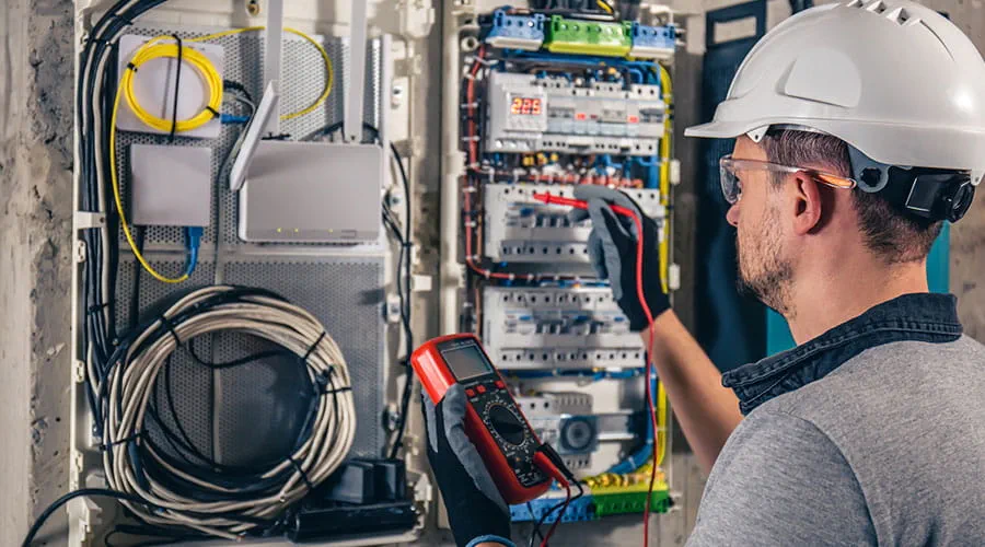 Técnico eléctrico que trabaja en una centralita con fusibles