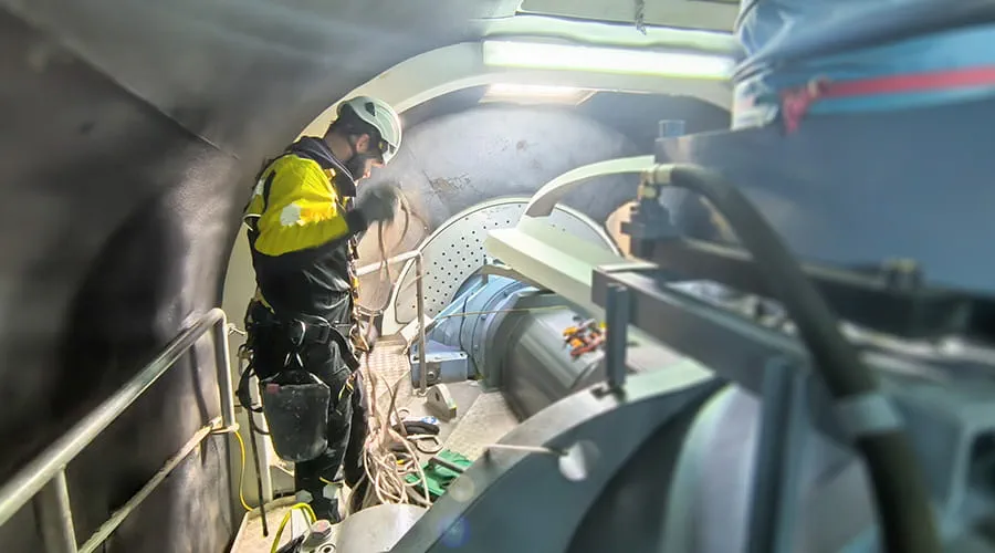 Técnico arreglando en el interior de una turbina eólica