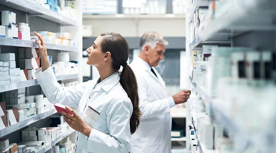 Farmacéuticos revisando stock de medicamentos Farmacéuticos revisando stock de medicamentos