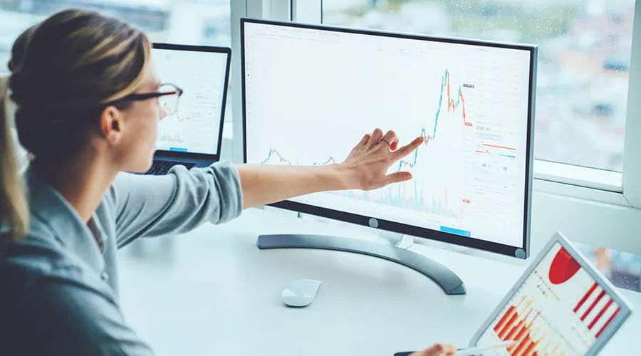 Mujer revisando estudios financieros en una pantalla