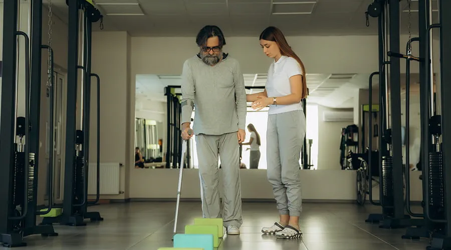 Hombre mayor haciendo fisioterapia con terapeuta en la clínica