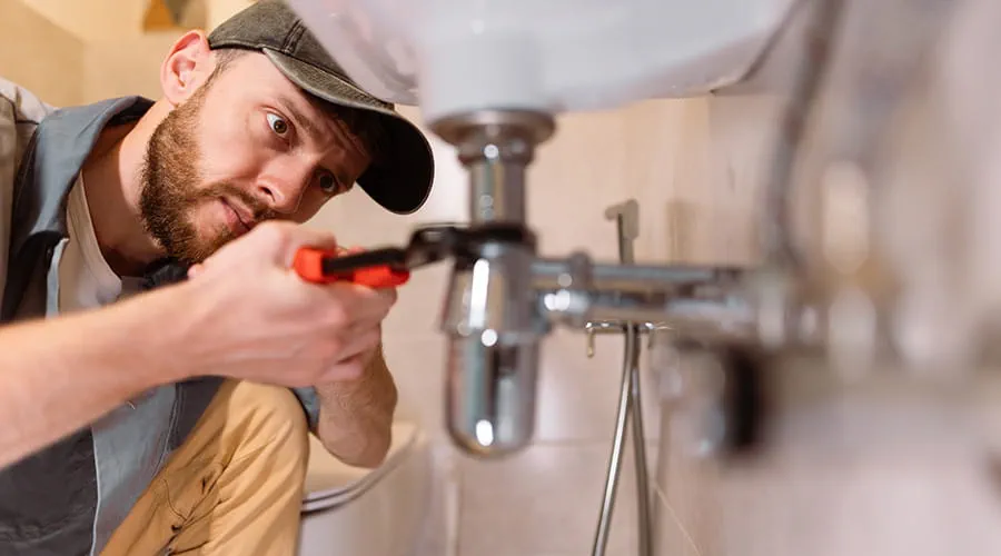 Fontanero arreglando tubería del baño