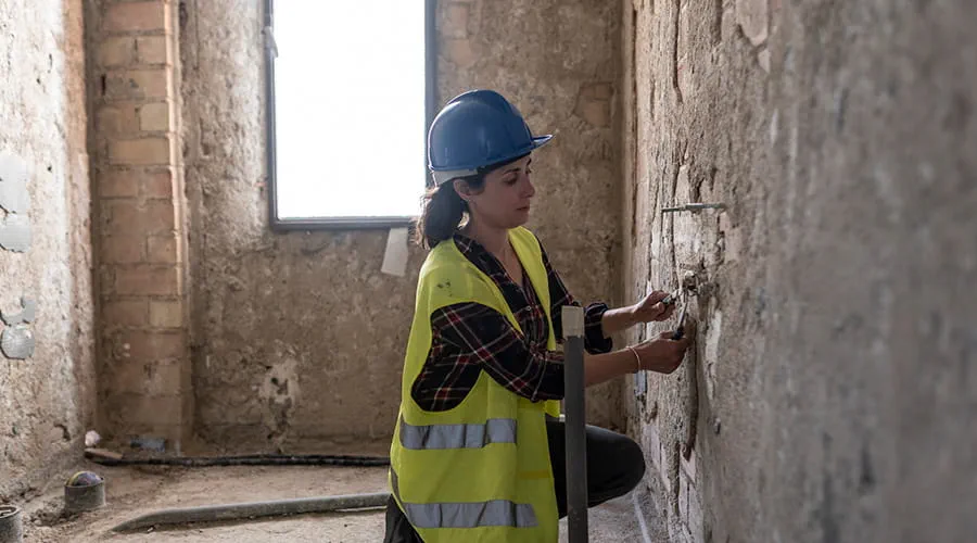 Fontanera arreglando tubos en obra