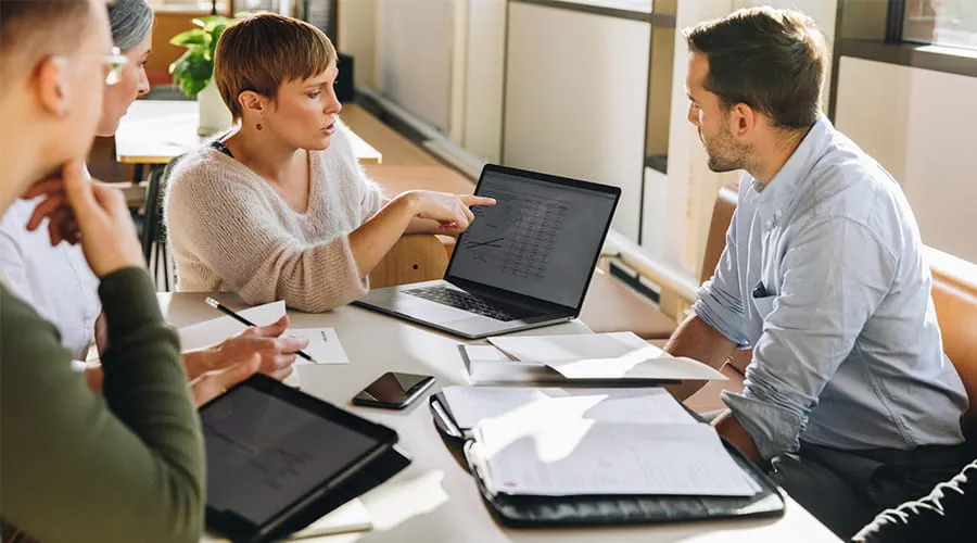 Ejecutiva mostrando datos al equipo en la reunión