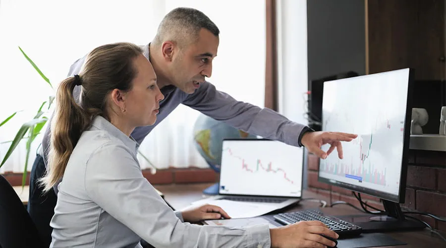 Dos personas revisando datos financieros en un ordenador