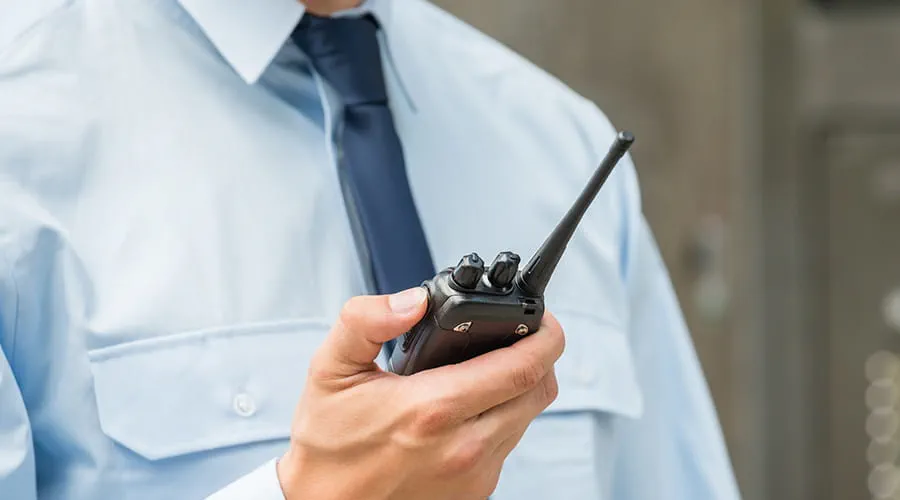 Guardia de seguridad sujetando un walkie talkie