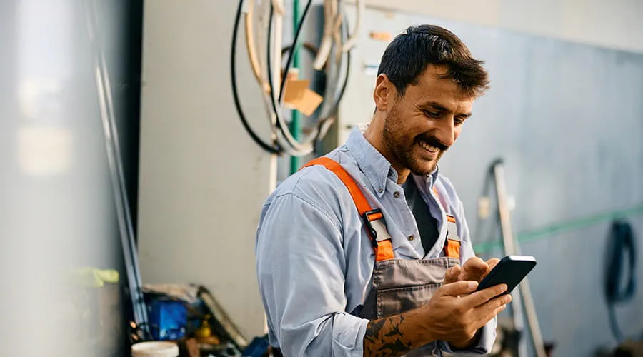 Ingeniero mecánico revisando en su teléfono inteliente los datos de reparación