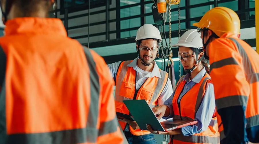 Ingenieros industriales reunidos para analizar los planos de la maquinaria