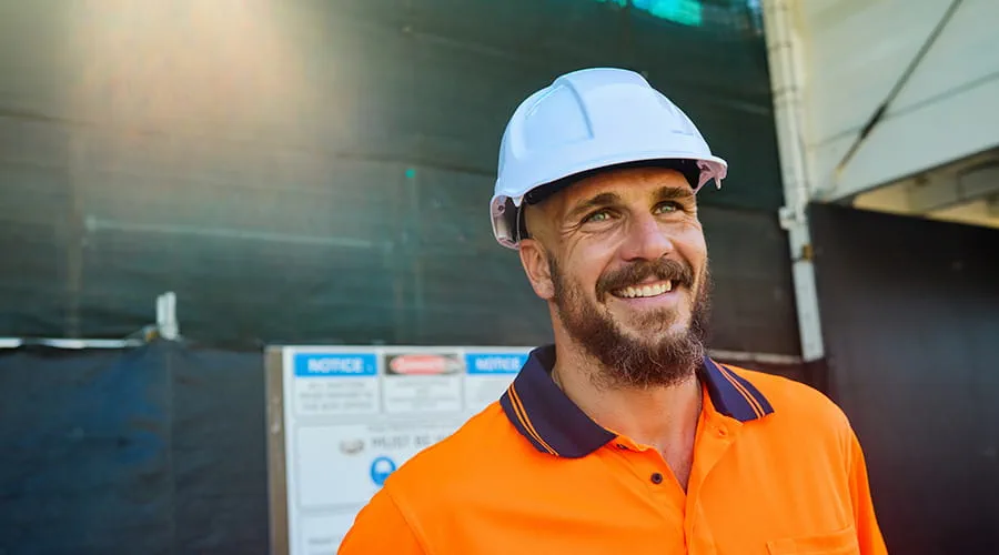 Ingeniero sonriente con casco en el sitio de construcción