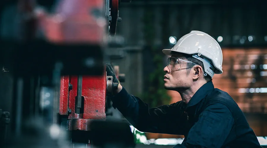 Ingeniero con casco de pie en una fábrica industrial