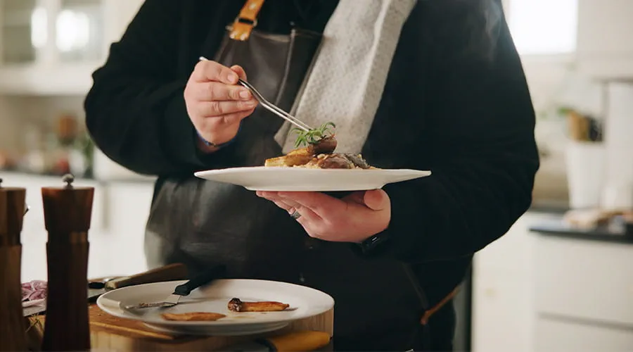 Chef terminando presentación plato de verduras